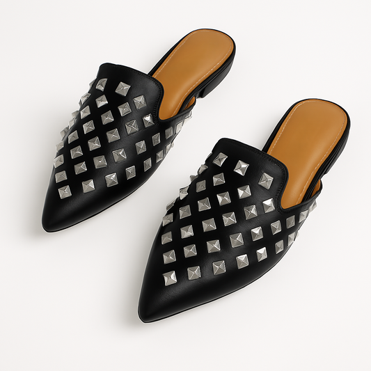 Slip into attitude with the Enny Studded Mules. Available in black faux leather or clear PVC, these pointed toe flats are your new go-to for effortless edge.